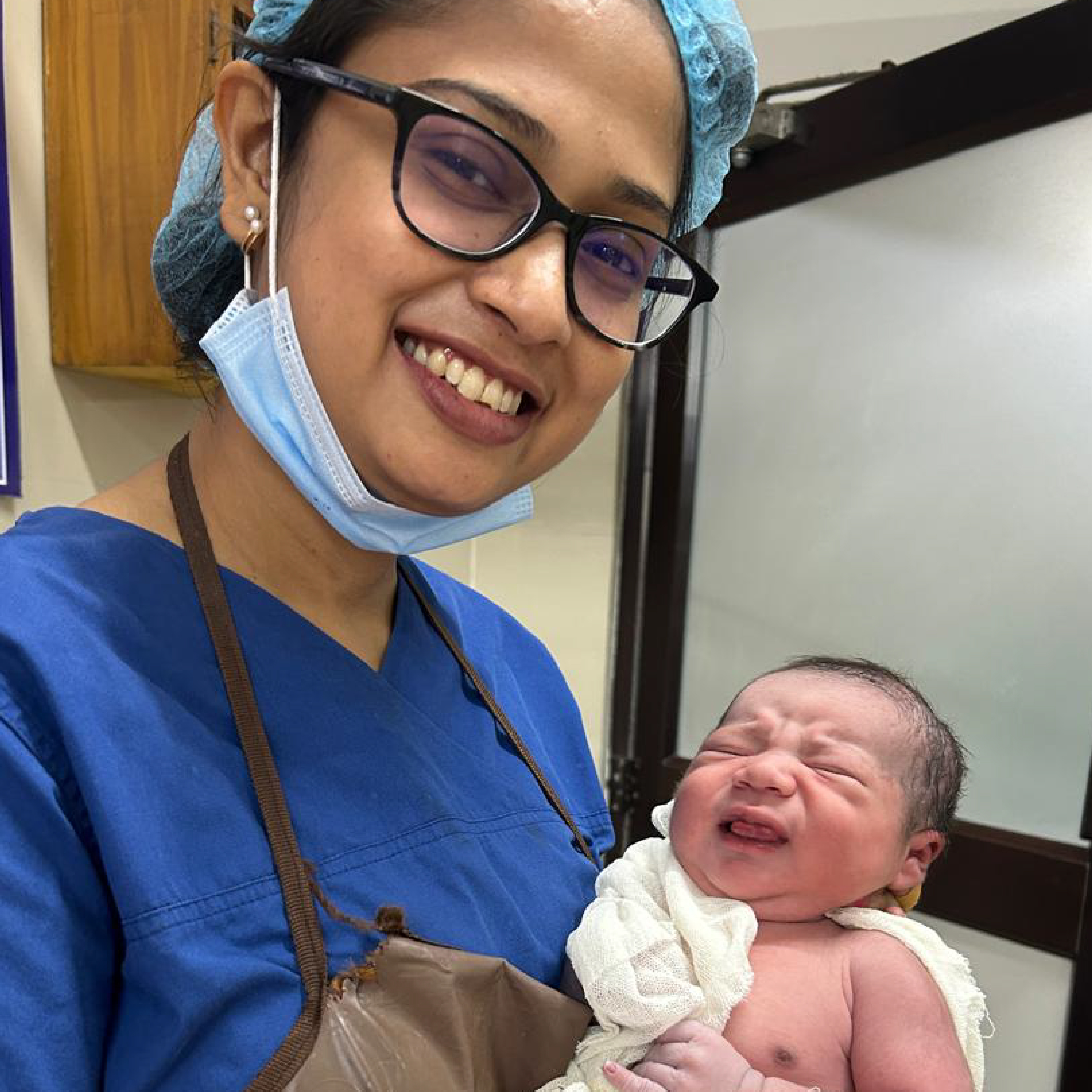 New parents holding their HomeIVF newborn with the treating fertility doctor