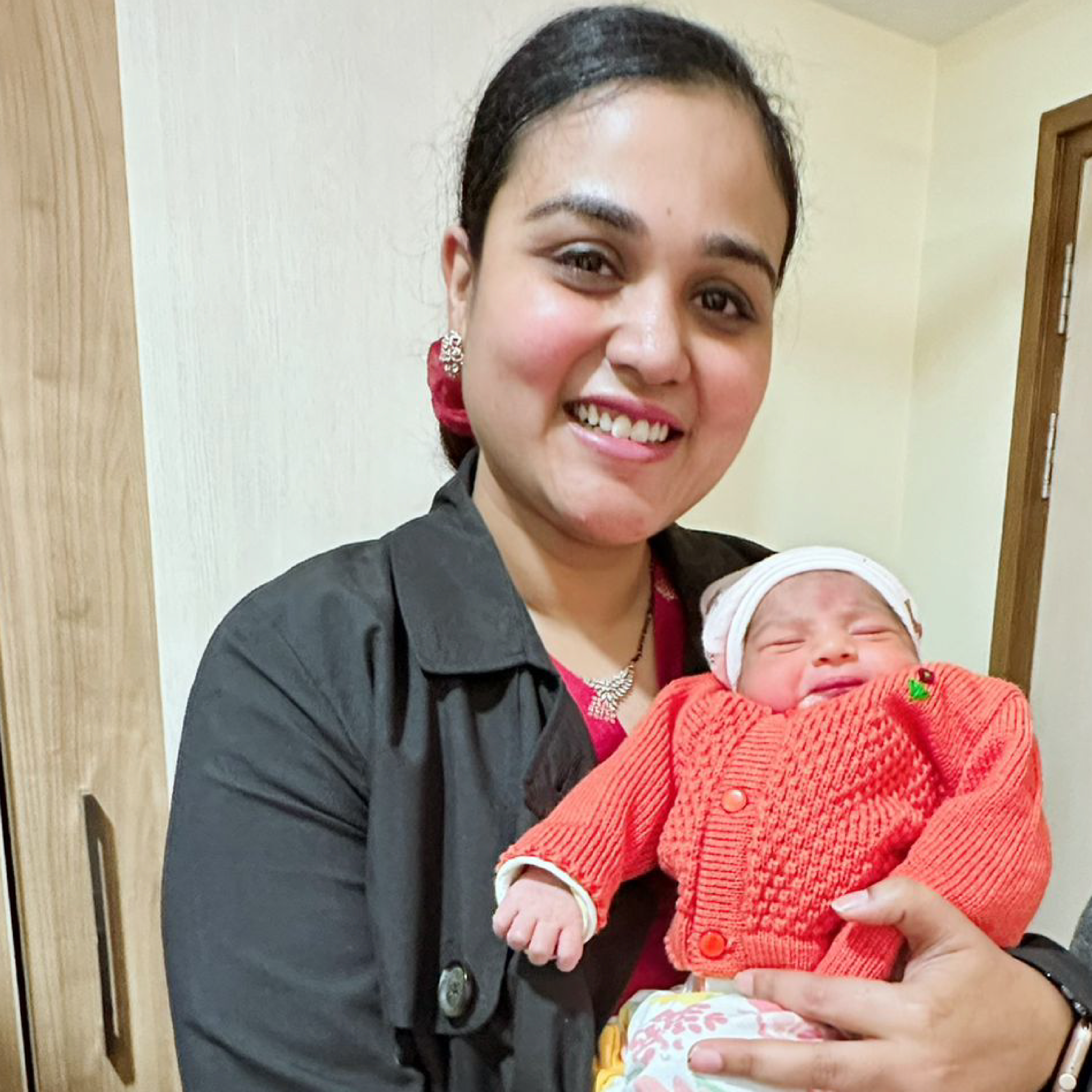 HomeIVF fertility doctor cradling a newborn HomeIVF baby in the delivery ward