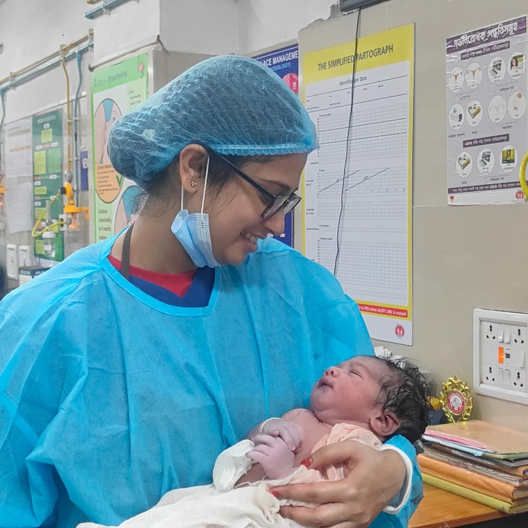 HomeIVF fertility doctor holding a sleeping HomeIVF newborn baby