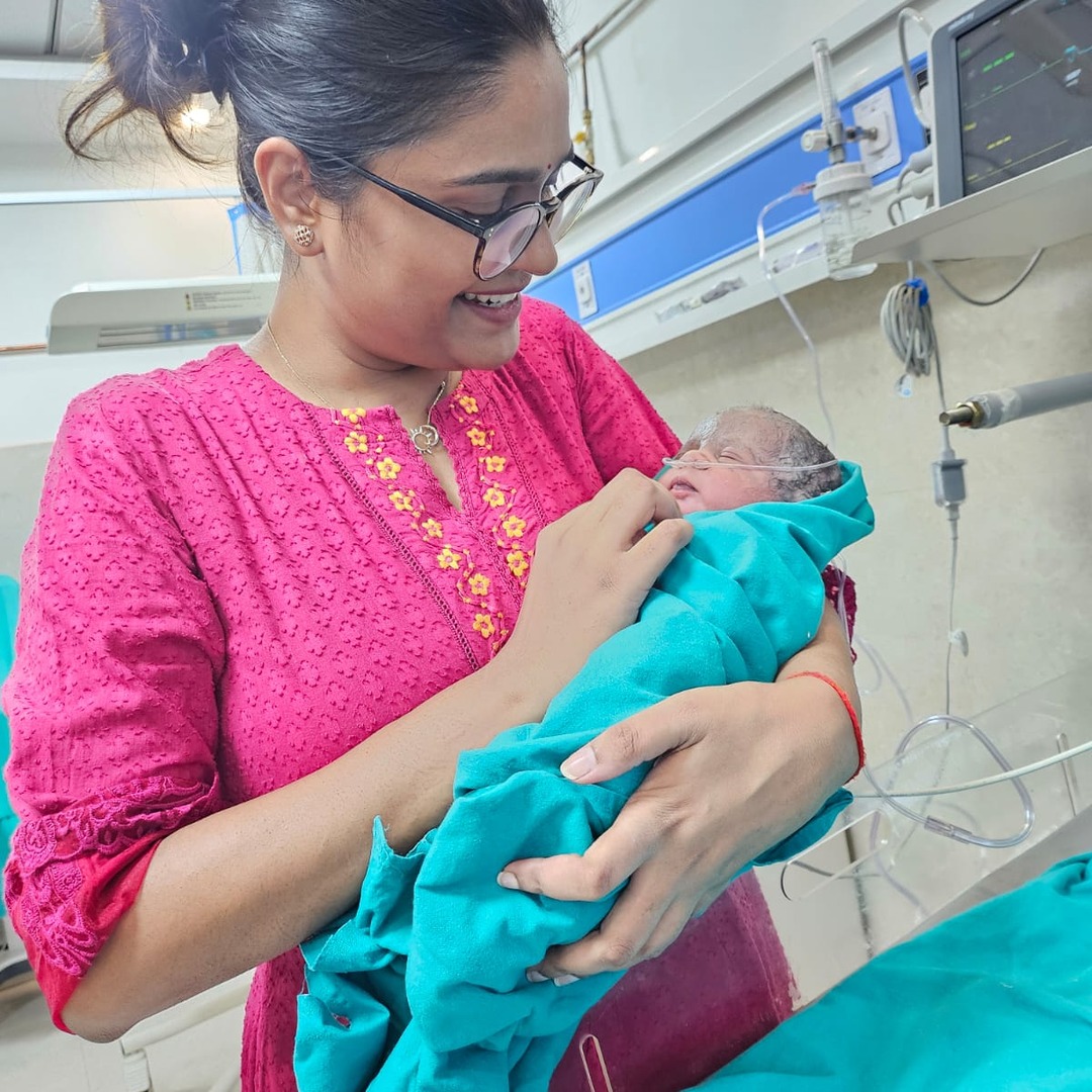 HomeIVF fertility specialist showing a newborn baby to the parents