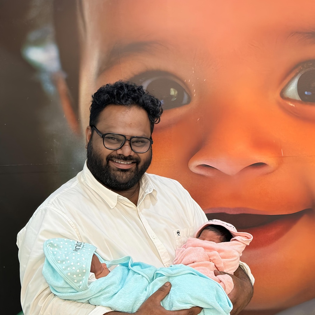 HomeIVF newborn baby sleeping in the arms of a HomeIVF fertility specialist